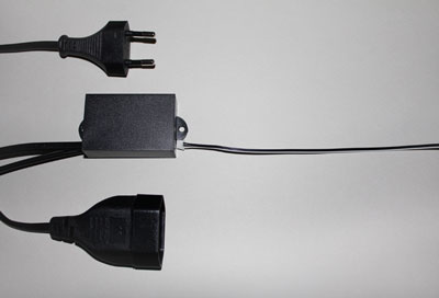 Ein Netzteil und ein Stecker sind mit einer Wandsteckdose verbunden.